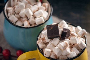 Bir fincan sıcak çikolata hatmi üstte ve koyu ahşap arka plan üzerinde lolipop sopa ile. Sıcak sıcak kış rustik kompozisyon