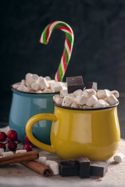 Bir fincan sıcak çikolata hatmi üstte ve koyu ahşap arka plan üzerinde lolipop sopa ile. Sıcak sıcak kış rustik kompozisyon