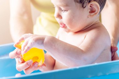 Anne küçük çocuk mavi bir banyo yıkama. Çocuk ile sarı ördek banyo. Hijyen ve su arıtma evde bebekle
