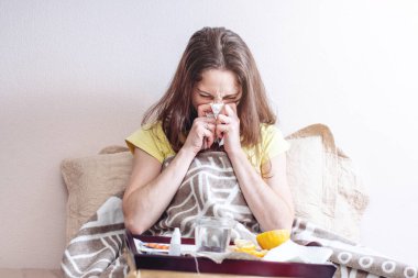 Bir baş ağrısı ve grip termometre ile yatakta kadın ile tabletler ve vitaminler ile tedavi edilir. Kışın mevsimlik soğuk algınlığı