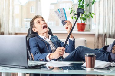 Genç adam kazandı biletleri tutuyor. Yolculuk için bekleyen bir sevinç. Office tatil kavramı