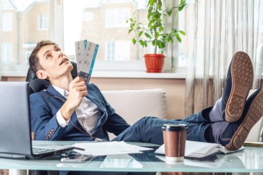 Genç adam kazandı biletleri tutuyor. Yolculuk için bekleyen bir sevinç. Office tatil kavramı