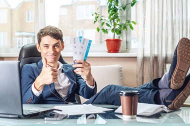 Genç adam kazandı biletleri tutuyor. Yolculuk için bekleyen bir sevinç. Office tatil kavramı