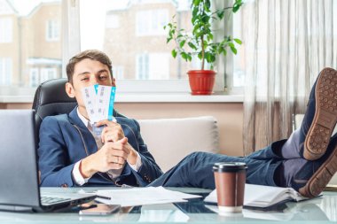 Genç adam kazandı biletleri tutuyor. Yolculuk için bekleyen bir sevinç. Office tatil kavramı