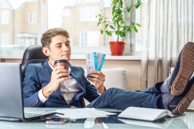 Genç adam kazandı biletleri tutuyor. Yolculuk için bekleyen bir sevinç. Office tatil kavramı