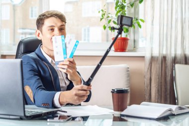 Uçak Bileti onun elinde olan bir genç adam işadamı blogger sevinç bir video kaydı tarafından aboneleri ile paylaşır. Office tatil kavramı