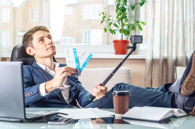 Uçak Bileti onun elinde olan bir genç adam işadamı blogger sevinç bir video kaydı tarafından aboneleri ile paylaşır. Office tatil kavramı