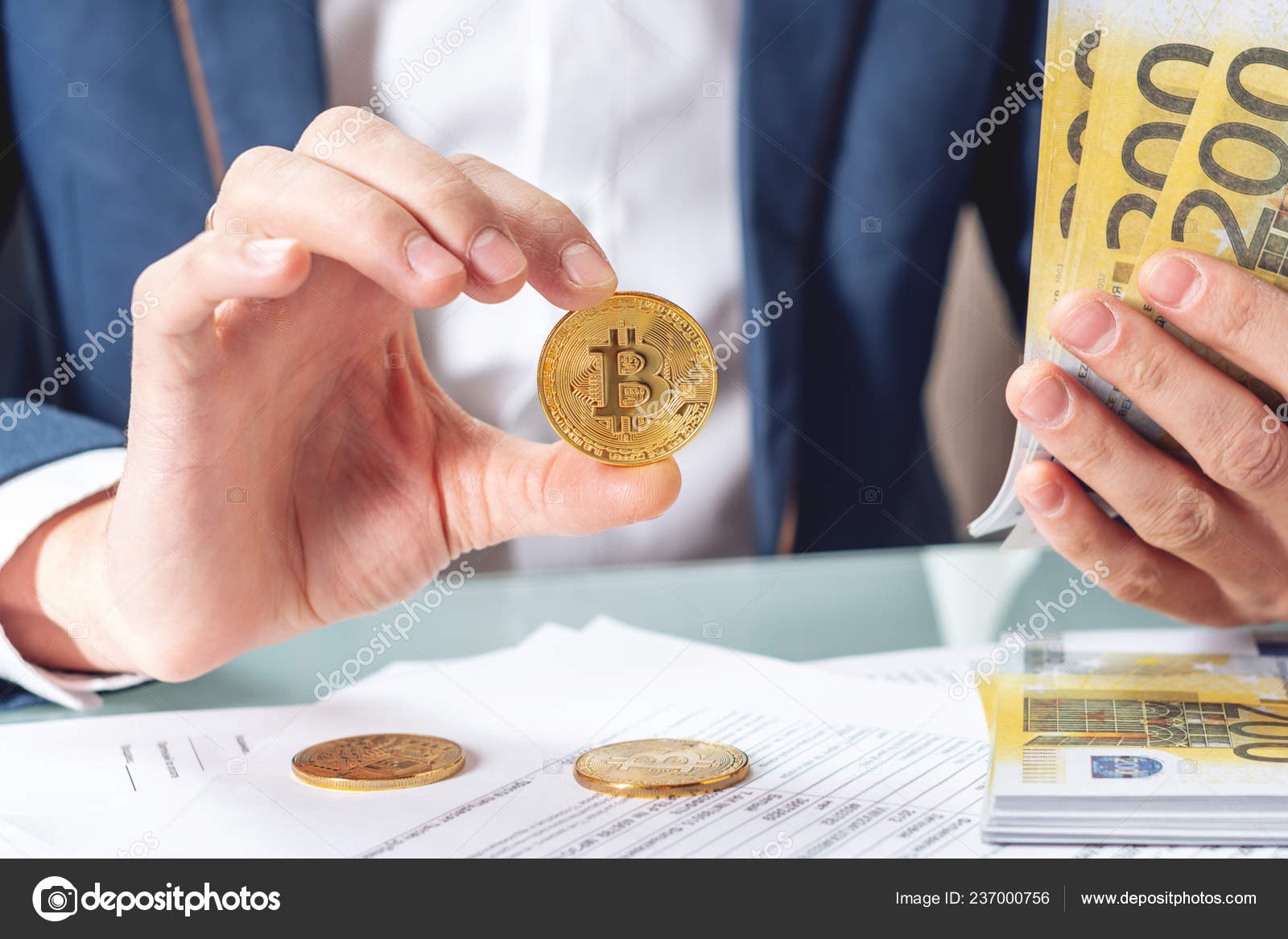 商人银行家坐在桌旁拿着一枚硬币的文件欧元加密货币兑换与销售的概念——图库图片© artoleshko #237000756