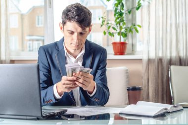 İşadamı işyerinde ofiste oturan resmi para sayma elleriyle rüşvet alır. Yolsuzluk ve rüşvet kavramı