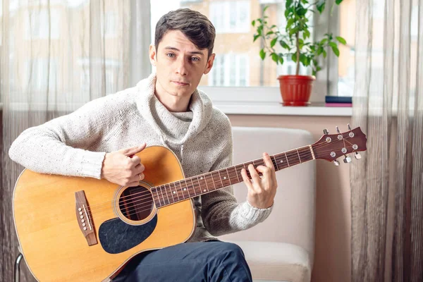 Joven Músico Masculino Atractivo Sentado Una Silla Tocando Guitarra Acústica — Foto de Stock