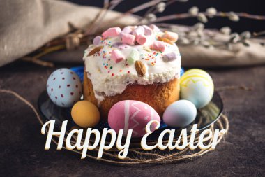 Geleneksel Paskalya kek ve renkli yumurta ve karanlık bir arka plan üzerinde rustik tarzı metin. Konsept tatil kartı