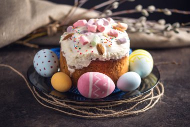 Geleneksel tatlılar ve rustik tarzı karanlık bir arka plan üzerinde renkli yumurta ile kartı. Kavram Mutlu Paskalya