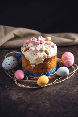 Geleneksel tatlılar ve rustik tarzı karanlık bir arka plan üzerinde renkli yumurta ile kartı. Kavram Mutlu Paskalya