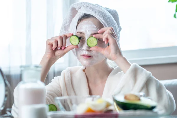 Mooie Gelukkig Jonge Vrouw Met Natuurlijke Cosmetische Masker Komkommer Plakjes — Stockfoto