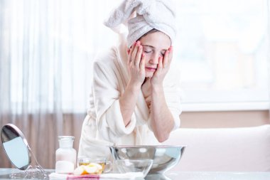 Sabah yüzünü su ile yıkama başında bir havlu ile güzel genç kadın. Kavramı hijyen ve evde cilt bakımı