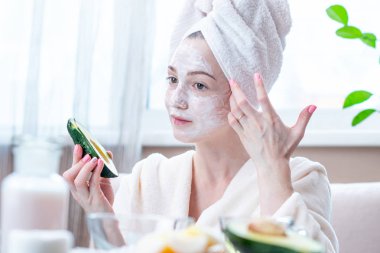 Kozmetik doğal avokado maskesi yüzünde güzel mutlu genç kadın. Kavram cilt bakımı ve Spa uygulamaları evde