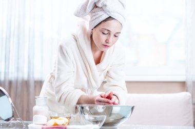 Sabah yüzünü su ile yıkama başında bir havlu ile güzel genç kadın. Kavramı hijyen ve evde cilt bakımı