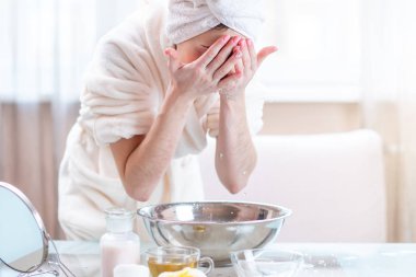 Yıkama ve yüz su ile sabah serinletici başında bir havlu ile güzel genç kadın. Kavramı hijyen ve evde cilt bakımı