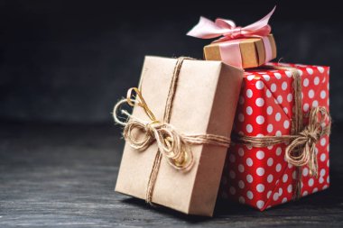 Tatil hediye kutuları, kağıt ve koyu ahşap arka plan üzerinde kırmızı lekeli işçiliği Paketli. Metin için hediyeler ve yer ile güzel kartları kavramı