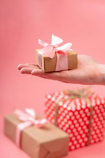 Női Kezei Díszdobozban Packed Nátronpapír Rózsaszín Háttér Koncepció Holiday Kártya — Stock Fotó