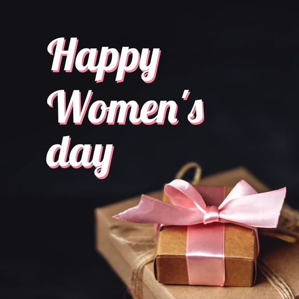 Holiday gift boxes Packed in crafting paper on dark wooden background. Square card Happy Women's day with text