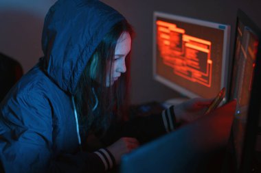Telefonu mobil cihaz bulut kesmek ve neon ışık altında karanlıkta verileri çalmak için ellerini tutarak başlıklı kız hacker. Siber güvenlik kavramı