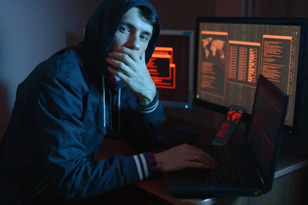 在引擎盖里的男性在镜头里看 黑客攻击和网络欺诈在黑暗中的屏幕背景在霓虹灯下 网络安全的概念 — 图库照片