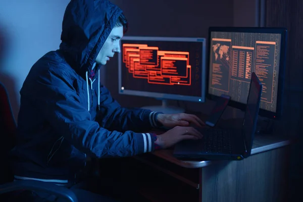 一名男性黑客在引擎盖中输入程序代码 同时实施网络犯罪 在霓虹灯下的屏幕背景下黑客攻击系统防火墙 网络安全概念 — 图库照片
