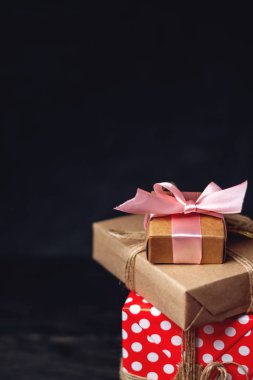 Tatil hediye kutuları, kağıt ve koyu ahşap arka plan üzerinde kırmızı lekeli işçiliği Paketli. Metin için hediyeler ve yer ile güzel kartları kavramı