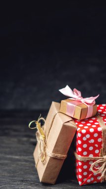 Tatil hediye kutuları, kağıt ve koyu ahşap arka plan üzerinde kırmızı lekeli işçiliği Paketli. Metin için hediyeler ve yer ile güzel kartları kavramı