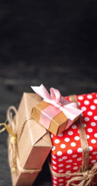 Tatil hediye kutuları, kağıt ve koyu ahşap arka plan üzerinde kırmızı lekeli işçiliği Paketli. Metin için hediyeler ve yer ile güzel kartları kavramı