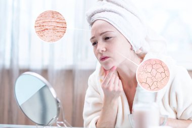 Onun baş Kuru cildi ilk kırışıklık ve çatlaklar ile görünümlü bir havlu ile güzel genç kadın. Daireler bir büyüteç büyüteç gibi cilt artırın