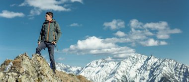 Adam Turizm güneşli bir arka plan karlı dağların üzerinde başarı duran kutlamak. Motivasyon ve hedeflerine ulaşılmasına kavramı