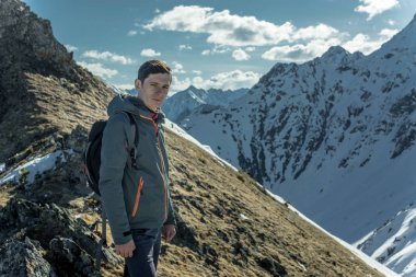 Adam Turizm güneşli bir arka plan karlı dağların üzerinde başarı duran kutlamak. Motivasyon ve hedeflerine ulaşılmasına kavramı