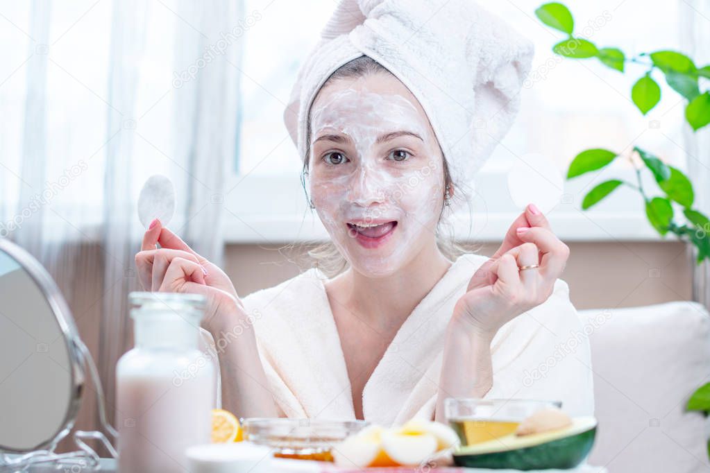 Beautiful happy young woman with natural cosmetic mask on her face. Concept skin care and Spa treatments at home