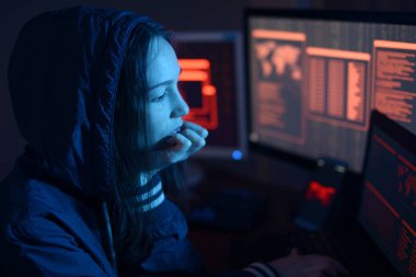 Kapüşonlu hacker kız neon ışık kodları ile ekranların arka planda kesmek veya kötü amaçlı yazılım enfeksiyonu sorunu hakkında düşünüyor. Siber güvenlik kavramı