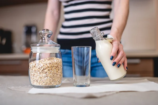 Una Mujer Vierte Leche Avena Orgánica Una Botella Vaso Cocina — Foto de Stock