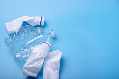 Bir yığın içinde temiz plastik çöp kullanılır. Mavi arka plandaki şişeler. Çevre kirliliği ve atık ayıklama kavramı
