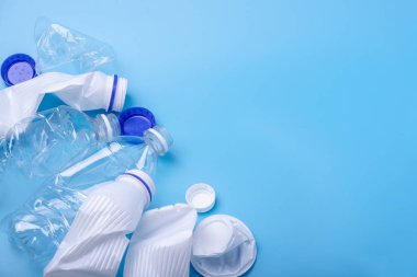 Bir yığın içinde temiz plastik çöp kullanılır. Mavi arka plandaki şişeler. Çevre kirliliği ve atık ayıklama kavramı