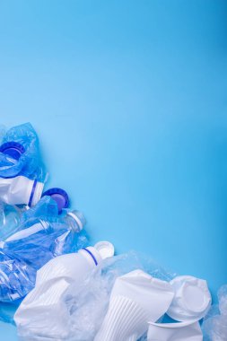 Bir yığın içinde sıralanmamış temiz çöp kullanılır. Şişeler, çantalar ve mavi arka plan üzerine kağıt. Kavram atıkları ayıklama. Metin için yer