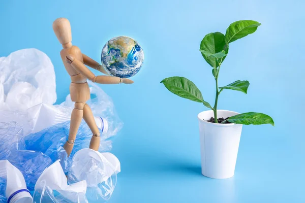 Hombre Forma Juguetes Madera Lleva Planeta Las Manos Planta Verde — Foto de Stock