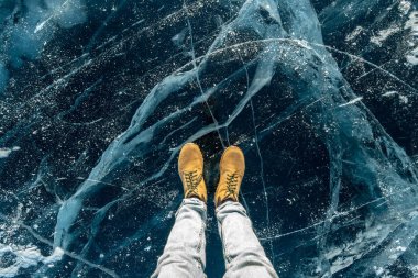 Baykal Gölü'nün saf mavi buzunda erkek sarısı ayakkabılar. Konsept turizm ve doğanın ünlü yerlerine seyahat