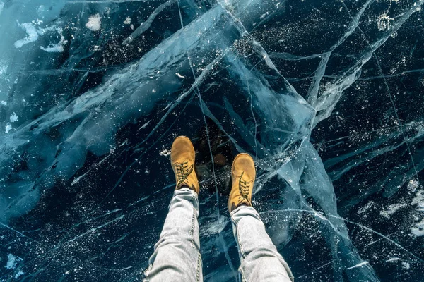 Мужская жёлтая обувь на чистом голубом льду озера Байкал. Концептуальный туризм и путешествия по известным местам природы — стоковое фото