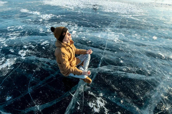 Turista utazó meditál ül a Lotus helyzetben a jég a tó Baikal — Stock Fotó