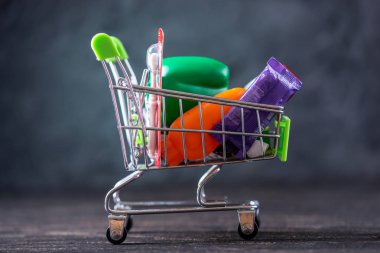 Karanlık bir arka plan üzerinde alışveriş sepeti günlük alımları. Mağazalarda ve süpermarketlerde alışveriş