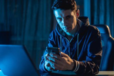 Bir dizüstü bilgisayarda çalışma gece genç bir adam. Tasarımcısı veya sistem yöneticisi geç saatlere kadar iş yerinde kaldı.