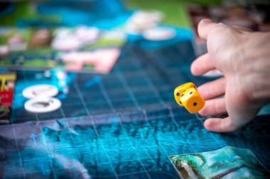 El mavi oyun alanına iki sarı zar atar. Oyun dinamikleri anlarda. Kavramı masa oyunları strateji