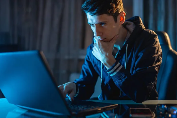 Anak muda bekerja pada laptop di malam hari. Desainer freelancer atau administrator sistem tetap terlambat bekerja . — Stok Foto