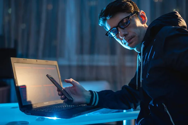 Pria berkacamata yang mengerjakan laptop di malam hari. Desainer freelancer mencoba untuk memecahkan masalah dengan tetap lembur di tempat kerja . — Stok Foto