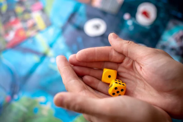 Hände werfen gelbe Würfel auf das Spielfeld. Glück und Aufregung. Konzept der Brettspiele. Spielmomente in Dynamik — Stockfoto